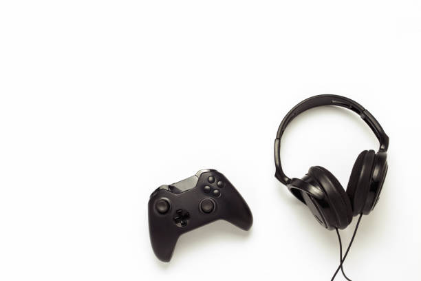 istock Black headphones and a gamepad on a white isolated background. C 1183070584