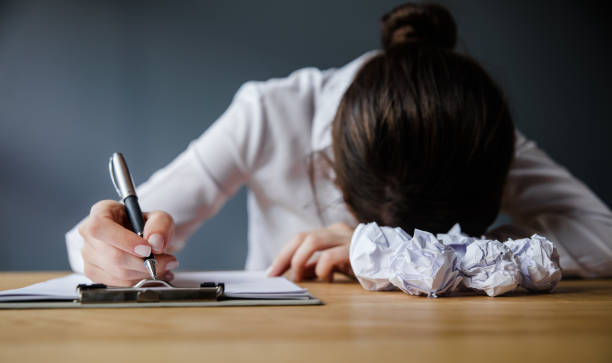 businesswoman on the table with paper balls - paper crumpled letter ideas imagens e fotografias de stock