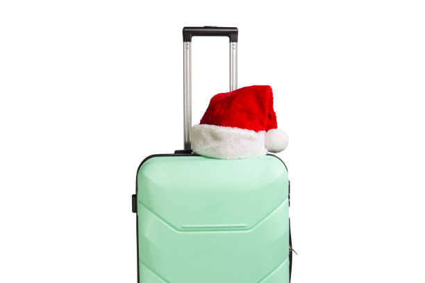 istock Plastic suitcase and Santa Claus hat on a white background. Conc 1183074945