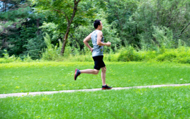 istock Man running in park footpath 1183075136