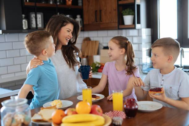 istock Mother and three kids in the kitchen eating breakfast 1183075434