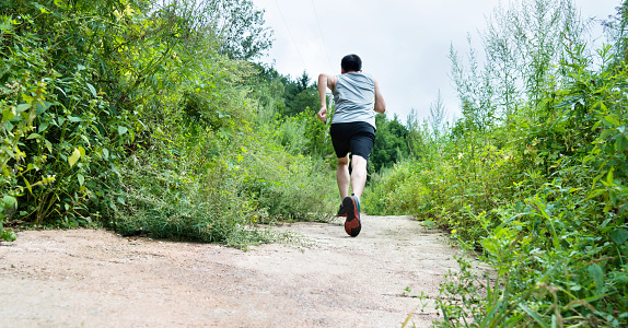 Man running on forest path