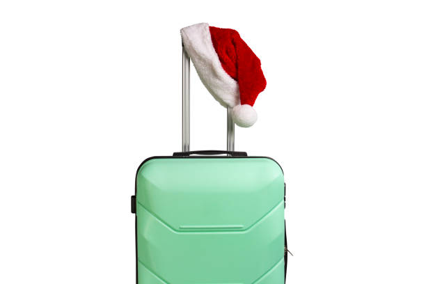 istock Plastic suitcase and Santa Claus hat on a white background. Conc 1183076068