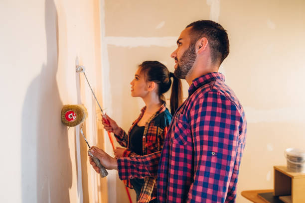 istock Young couple painting wall 1183077086