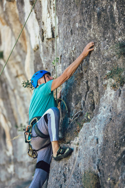 istock Senior man with a rope climbing on the rock. 1183078264