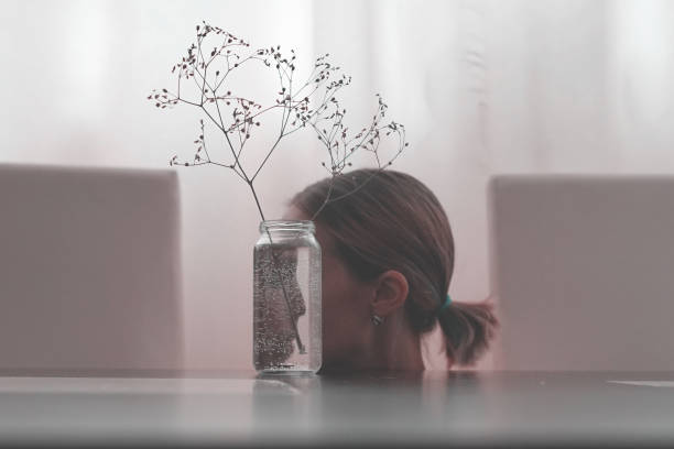 The girl's face reflected in glass jar.