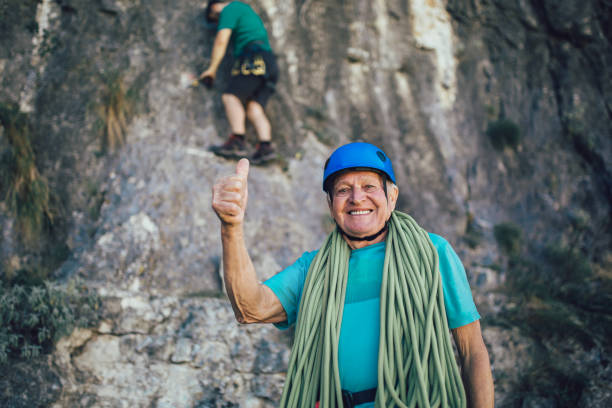 istock Senior man with a rope preparing for climbing on the rock. 1183078603
