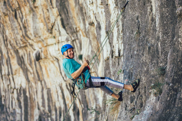 istock Senior man with a rope climbing on the rock. 1183079346