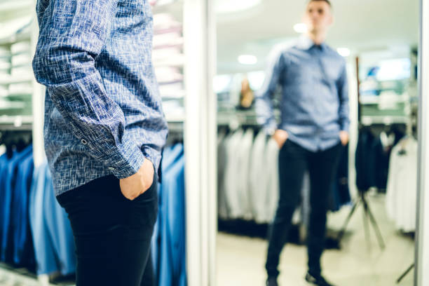 istock Man trying shirt in a store 1183079600