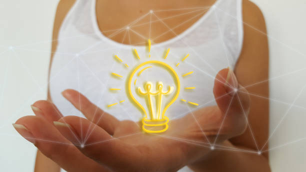 istock Businesswoman using digital light bulb on network connection hologram 1183082915