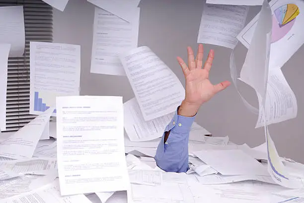 Photo of Business man drowning in paperwork