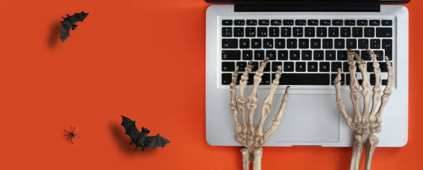 mani scheletro che digitano nel laptop - skeleton key key computer keyboard laptop foto e immagini stock