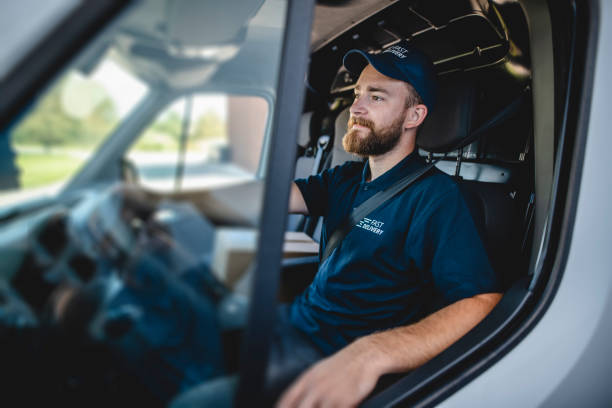 Young Male Gig Driver Waiting to Get Started on Deliveries Side view of confident young independent delivery expert sitting in driver’s seat of van ready to begin transport. service occupation stock pictures, royalty-free photos & images