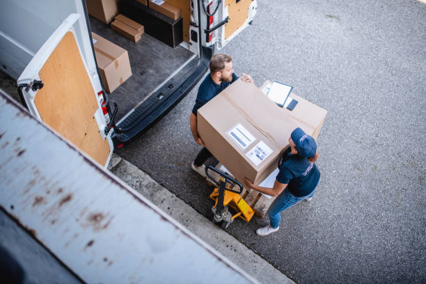 istock Gig Delivery Drivers Lifting Large Parcel Off Pallet Jack 1183087640
