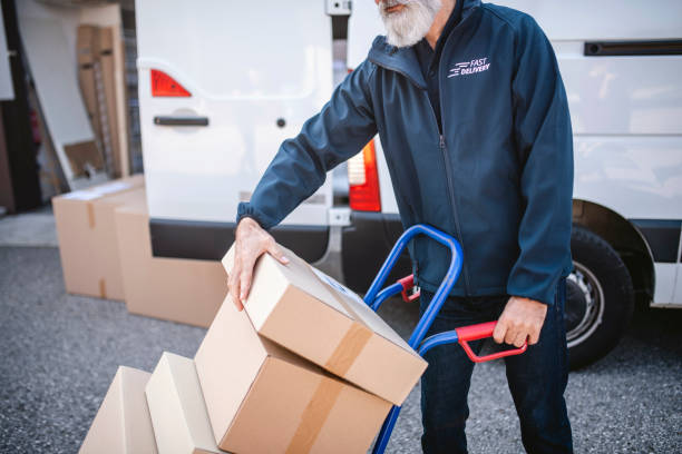 istock Bearded Delivery Expert Managing Packages on Hand Truck 1183087739