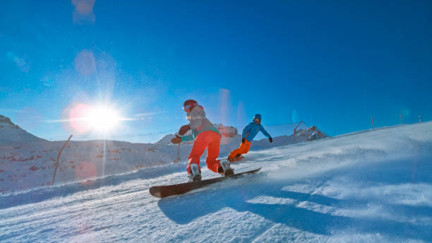istock Man and woman snowboarding on mountain 1183087930