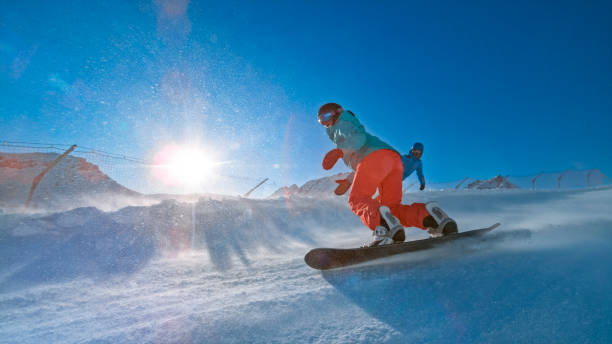 istock Man and woman snowboarding on mountain 1183087941