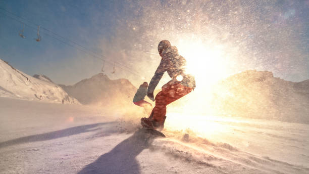 istock Man and woman snowboarding on mountain 1183087943