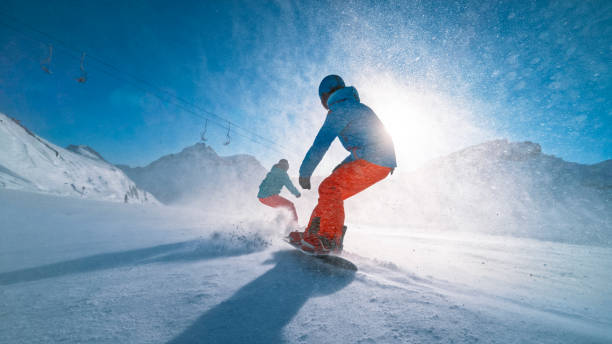 Man and woman snowboarding on mountain