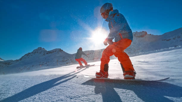 istock Man and woman snowboarding on mountain 1183087948
