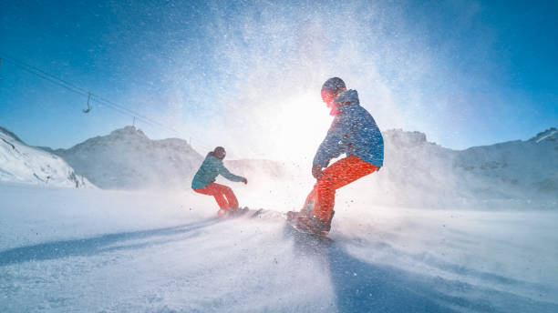 istock Man and woman snowboarding on mountain 1183087951