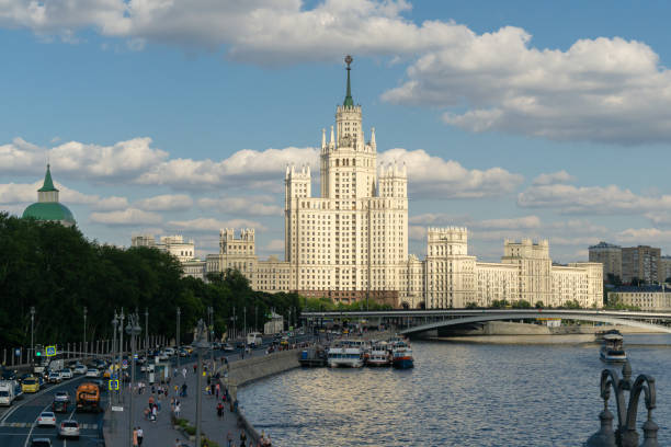 vue de coucher du soleil de gratte-ciel sur kotelnicheskaya embankment et rue de circulation sur moskvoretskaya embankment du pont flottant dans le parc de zaryadye. rivi�ère moskva avec des bateaux de plaisance. - kotelnicheskaya photos et images de collection