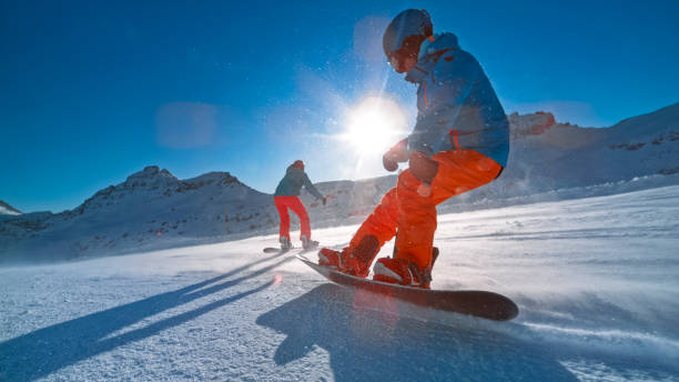istock Man and woman snowboarding on mountain 1183089018