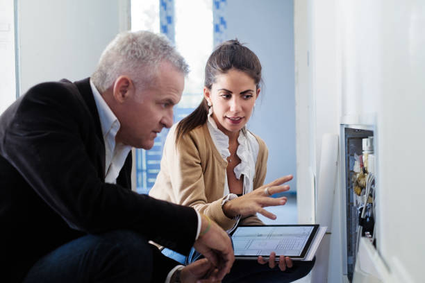 şantiyede asistana isıtma sistemi gösteren mimar - isıtma tesisatı mühendisi stok fotoğraflar ve resimler