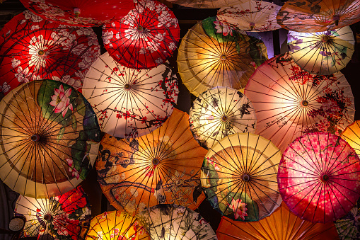 Top view on the traditional colored Chinese sunshade umbrellas. Traditional Chinese patterns and ornaments on the colorful wooden and paper umbrellas. Located in the souvenir store in Kuanzhai Xianzi alleys in Chengdu, Sichuan province, China.