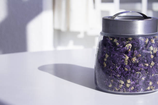 Pot with natural dried chamomile infusion. Isolated