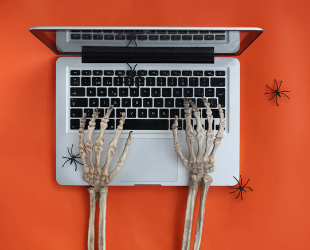 mani scheletro che digitano nel laptop - skeleton key key computer keyboard laptop foto e immagini stock