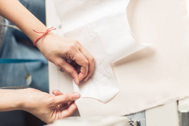 istock Seamstress unrips fabric near sewing-machine 1183100526