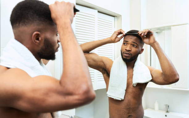 istock Awesome african american guy combing his hair at bathroom 1183102053