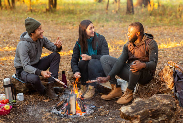 istock Happy friends sitting around fireplace, enjoying time together 1183103171