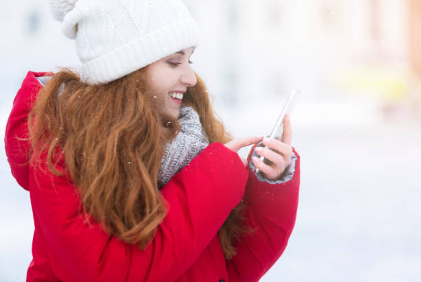 istock Attractive ginger girl looking at cellphone, checking on new messages 1183103307