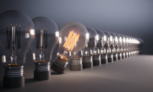 glowing light bulb standing out from the crowd - creative sustainability imagens e fotografias de stock