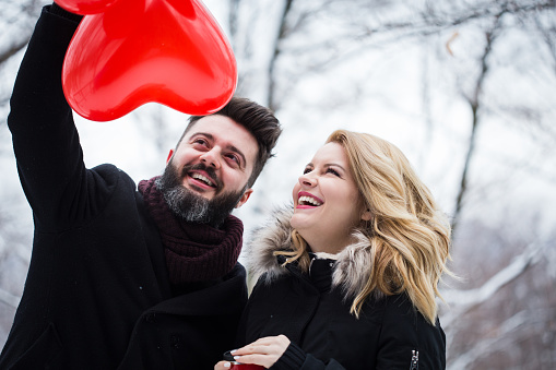 Couple in love with balloons - winter day of St. Valentine