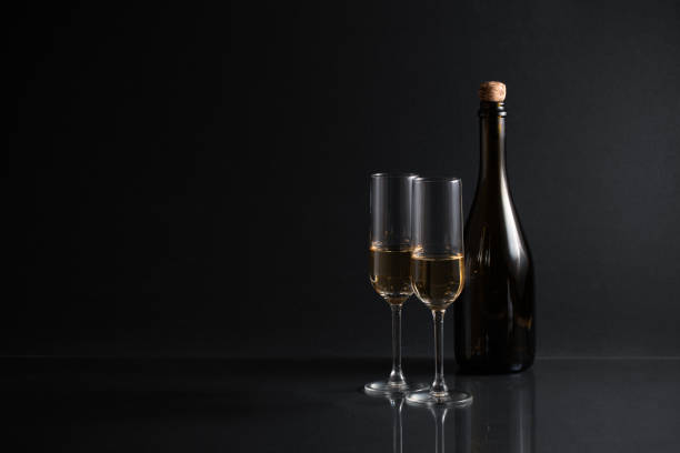 istock Champagne glass and blank bottle against black background 1183103682