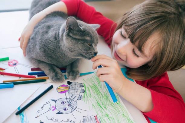 istock Child with cat drawing at home 1183104129