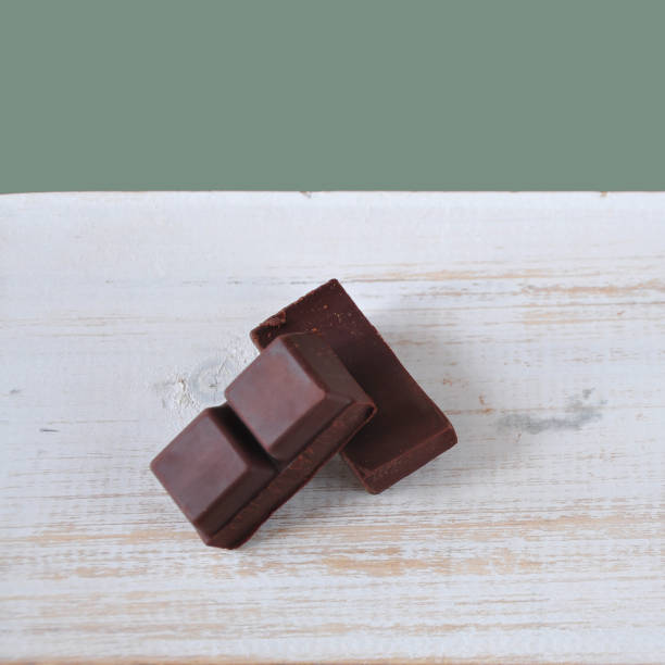 istock Dark Chocolate Bars on White Wooden with Pastel green Background 1183106205