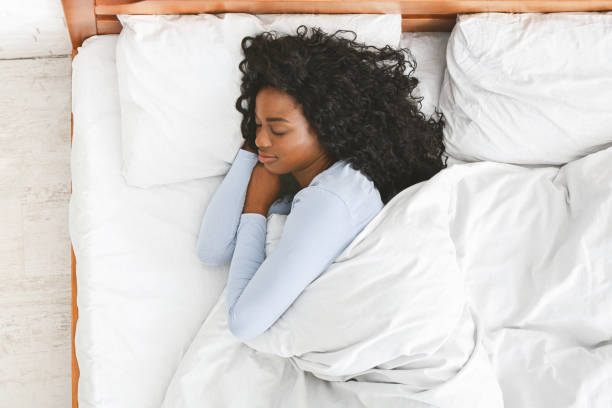 rear view of young woman sleeping in her bed - sensuality lifestyles cheerful comfortable imagens e fotografias de stock