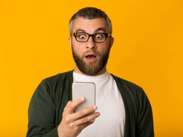 istock Amazed man looking at cellphone with eyes wide open 1183113245