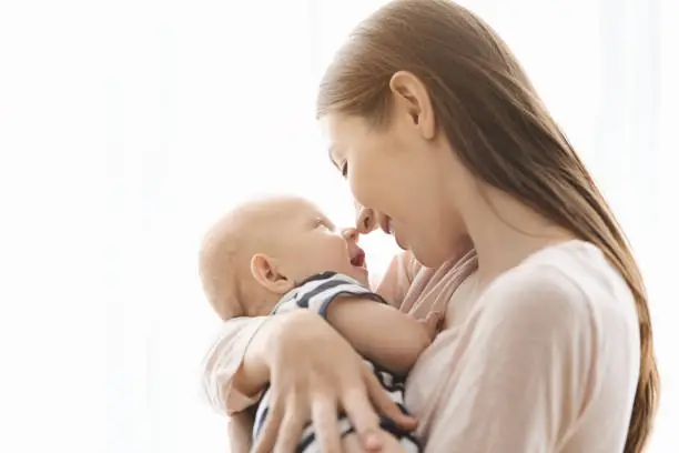 Photo of Happy mom touching noses with her cute little baby