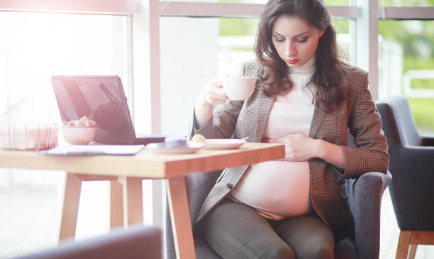 istock Pregnant woman working on computer in cafe 1183114018