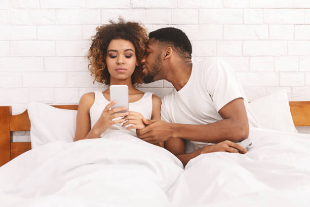 젊은 남자 성추행 그의 기분 좋은 아내 네트워킹 에 휴대 전화 - sexual activity black couple african descent 뉴스 사진 이미지