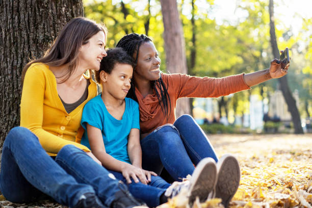 istock Multi ethnic friends with child taking selfie 1183119282
