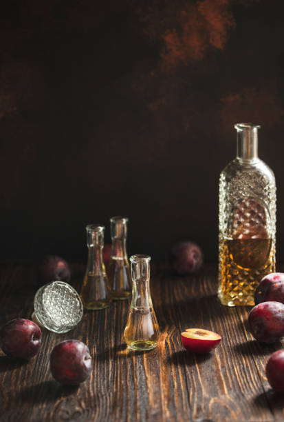 rakia o rakija tradizionale brandy di frutta balcanica. slivovica di brandy di prugne in un bicchiere che si chiama cokanj e bottiglia su un tavolo di legno e sfondo scuro. verticale. spazio di copia - vodka hard liquor bottle palinka foto e immagini stock