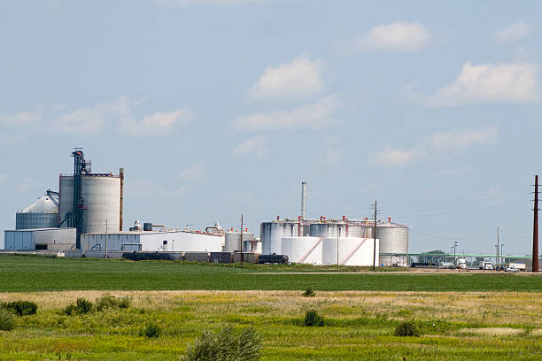 istock Ethanol plant sitting on large green field under blue sky. 118312005