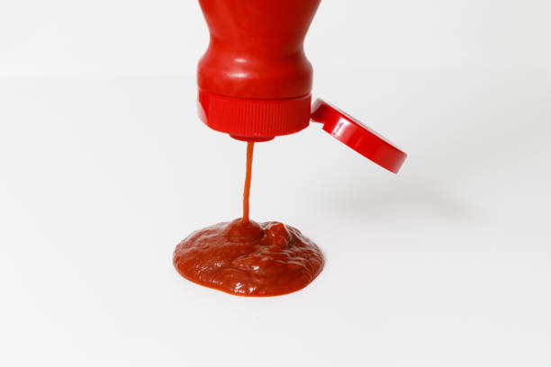 istock pouring ketchup on white background 1183126694