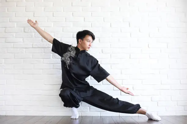 Photo of Asian young novice on a white brick wall